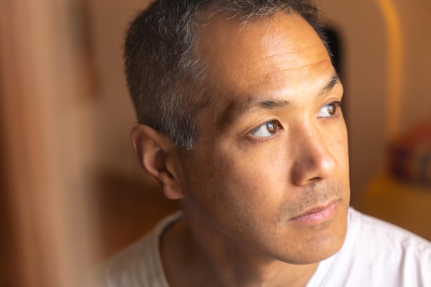 Portrait d'un jeune homme japonais triste regardant la fenêtre