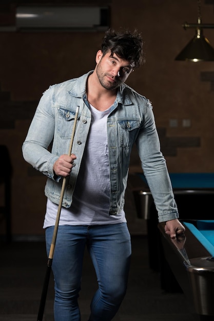 Portrait d'un jeune homme jouant au billard