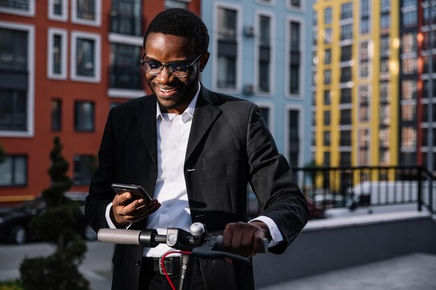 Portrait d'un jeune homme joyeux qui regarde le téléphone ne