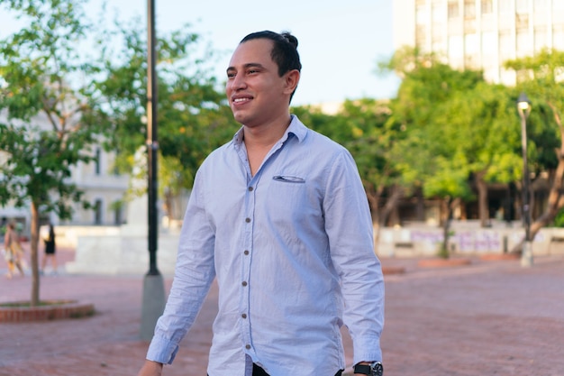 Portrait d'un jeune homme latino marchant dans le parc