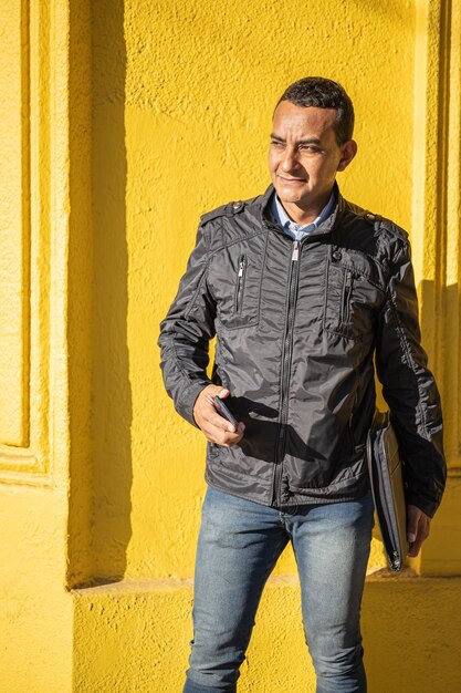 Portrait d'un jeune homme latino sur un mur jaune