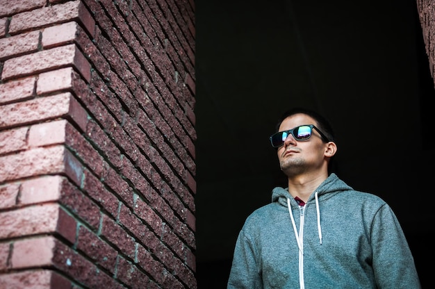 Portrait d'un jeune homme avec des lunettes dans la rue