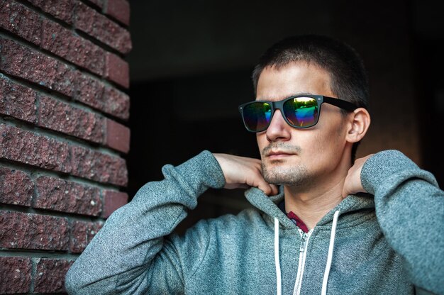 Portrait d'un jeune homme avec des lunettes dans la rue