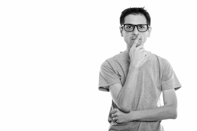 Portrait de jeune homme maigre nerd portant des lunettes isolé sur blanc en noir et blanc