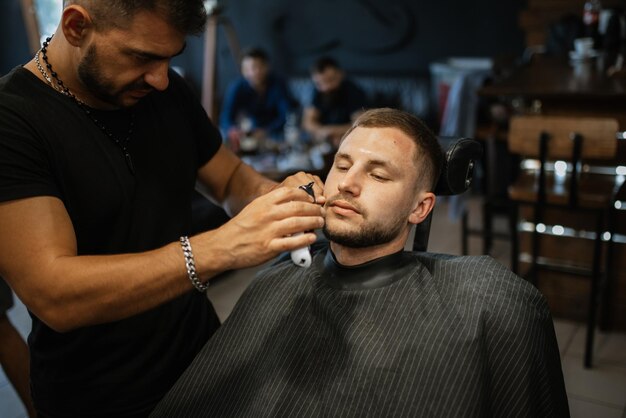 Portrait d'un jeune homme marié au camp d'entraînement dans le salon de coiffure