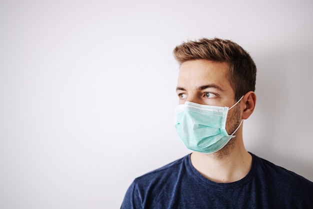 Portrait de jeune homme avec masque, regardant ailleurs. Restez à la maison, seul à la maison. Quarantaine.