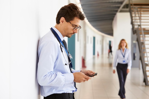 Portrait de jeune homme médecin avec stéthoscope et smartphone