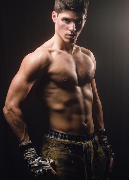 Portrait d'un jeune homme musclé sur un fond noir