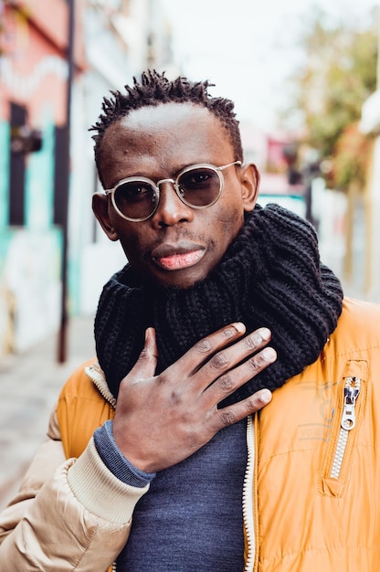 Portrait de jeune homme noir debout dans la rue en regardant la caméra