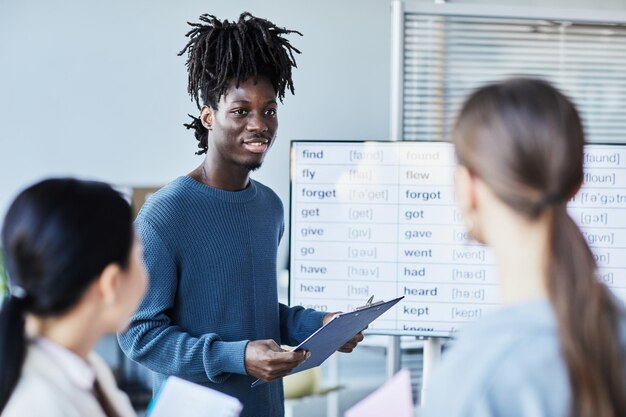Photo portrait d'un jeune homme noir en discussion de groupe lors d'un séminaire d'anglais au bureau