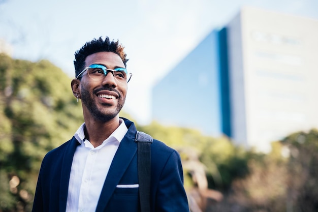 Portrait de jeune homme noir rêveur regardant l'infini dans un parc