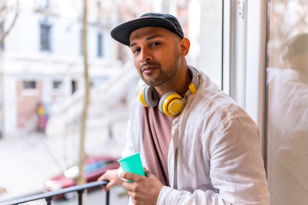 Portrait d'un jeune homme d'origine latino sur un balcon à la maison appartement de situation quotidienne