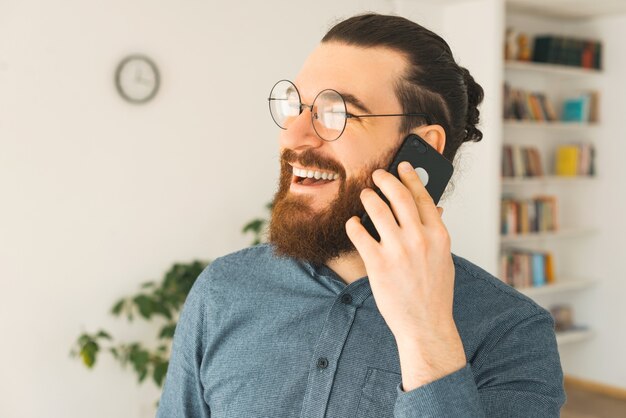 Portrait d'un jeune homme parlant à son téléphone au bureau