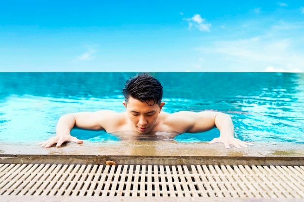 Portrait de jeune homme sur la piscine