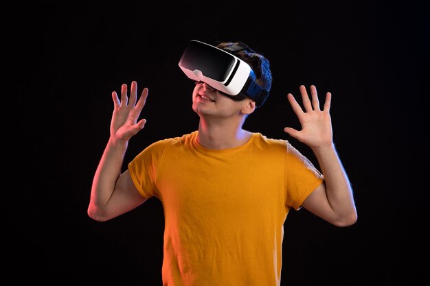 Portrait de jeune homme portant un casque vr sur le mur sombre