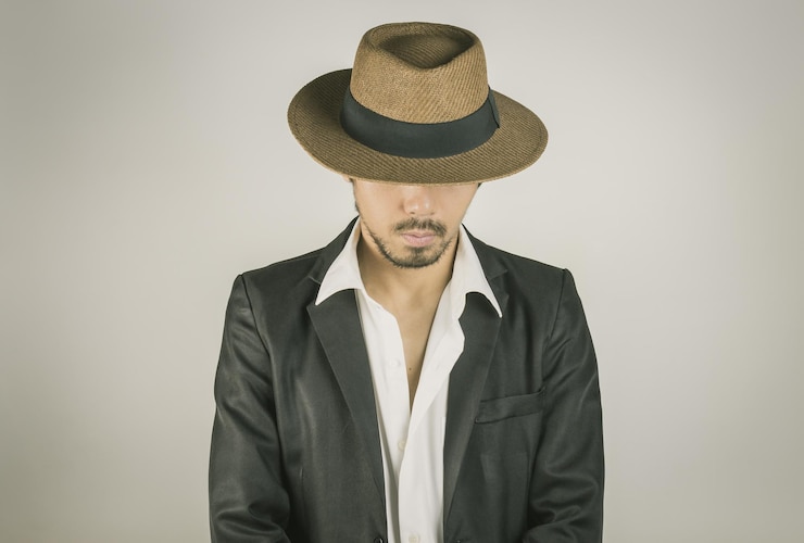 Photo portrait d'un jeune homme portant un chapeau sur un fond blanc