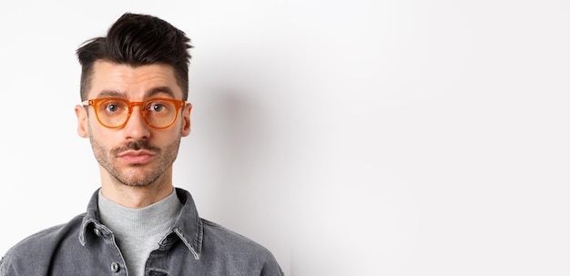 Portrait d'un jeune homme portant des lunettes de soleil sur un fond blanc