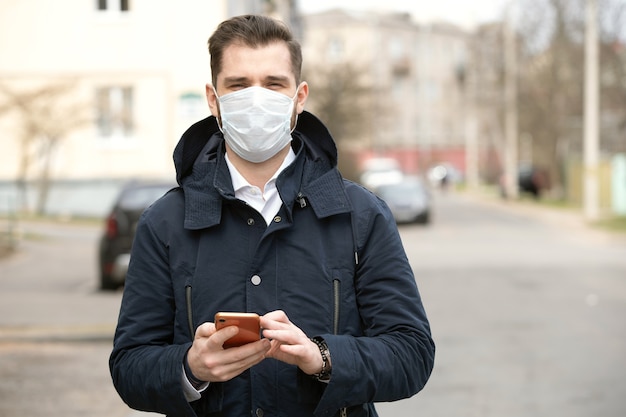 Portrait d'un jeune homme portant un masque de protection sur la rue