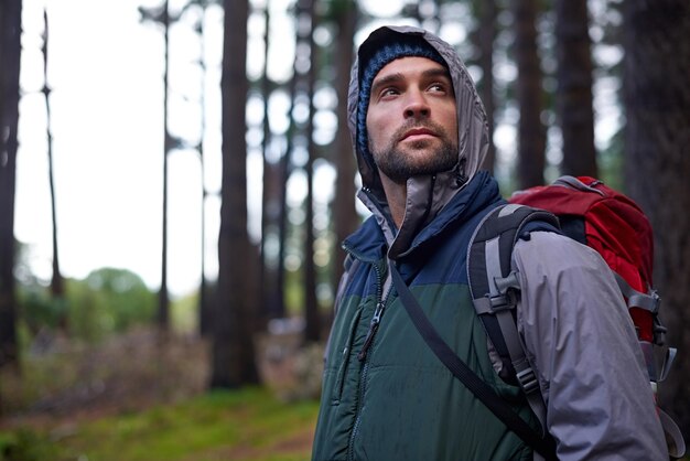 Portrait d'un jeune homme portant un sac à dos lors d'une randonnée dans la forêt