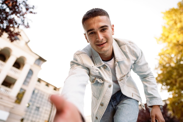 Portrait de jeune homme prenant un selfie tout en étant dans la rue de la ville en gros plan