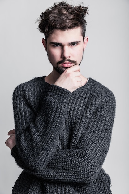 Portrait d'un jeune homme en pull gris