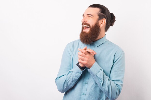 Portrait d'un jeune homme qui rit, main dans la main.