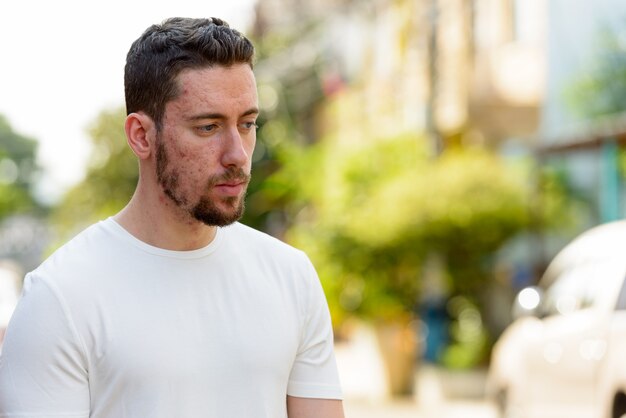 Portrait de jeune homme réfléchi à l'extérieur