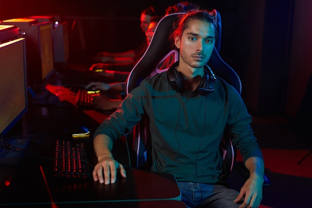 Portrait de jeune homme regardant la caméra pendant son jeu en club informatique