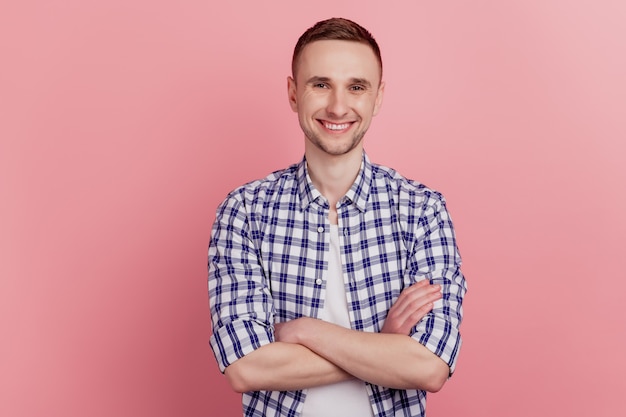 Portrait de jeune homme séduisant heureux sourire positif debout avec les bras croisés confiant isolé sur fond de couleur rose