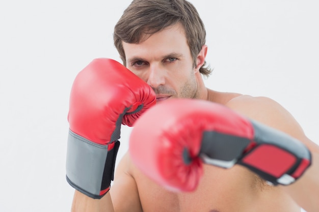 Portrait d&#39;un jeune homme sérieux avec des gants de boxe rouges