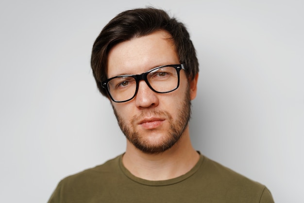 Portrait d'un jeune homme songeur sérieux sur fond gris close up