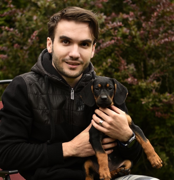 Portrait d'un jeune homme souriant avec un chien