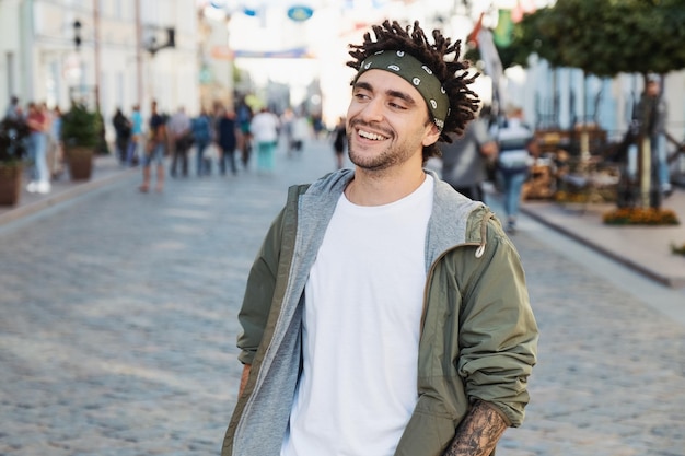 Portrait d'un jeune homme souriant dans la rue