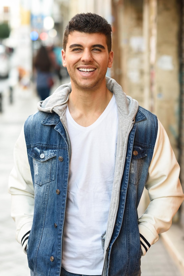 Photo portrait d'un jeune homme souriant debout sur le trottoir