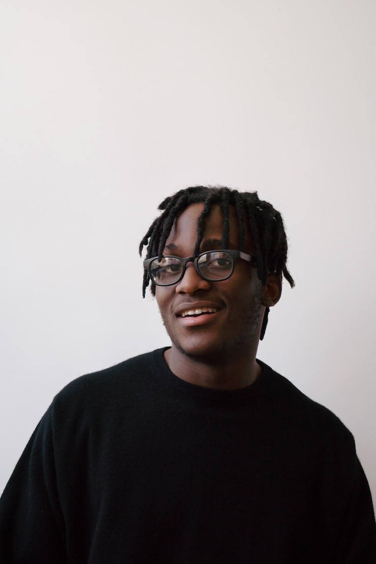 Photo portrait d'un jeune homme souriant sur un fond blanc.