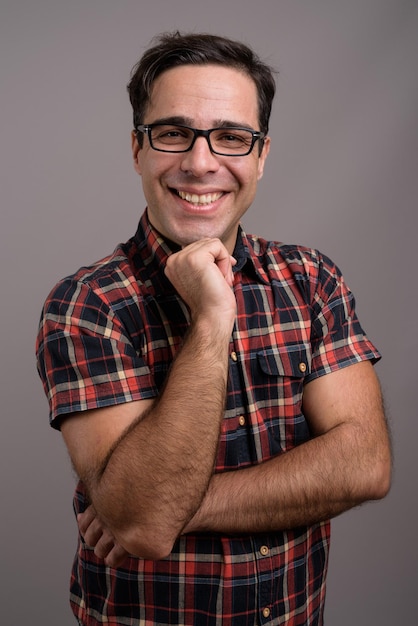 Photo portrait d'un jeune homme souriant sur un fond gris.