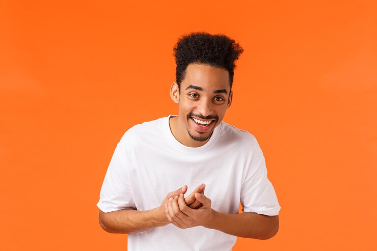 Photo portrait d'un jeune homme souriant sur un fond orange