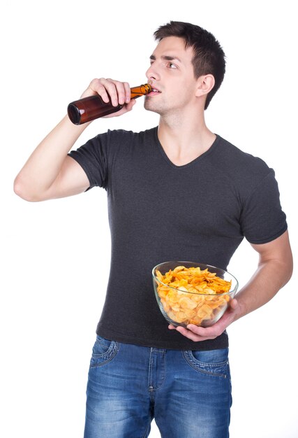 Portrait de jeune homme souriant avec des frites et de la bière.