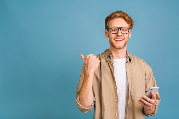 portrait de jeune homme souriant heureux en sms de frappe décontractée