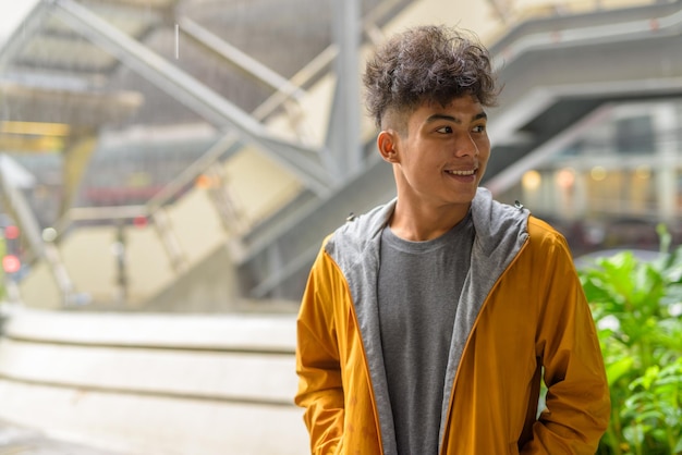 Photo portrait d'un jeune homme souriant qui détourne le regard