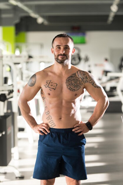 Portrait d'un jeune homme de tatouage en bonne forme physique montrant son corps bien formé Muscular Athletic Bodybuilder Fitness Model Posing After Exercises