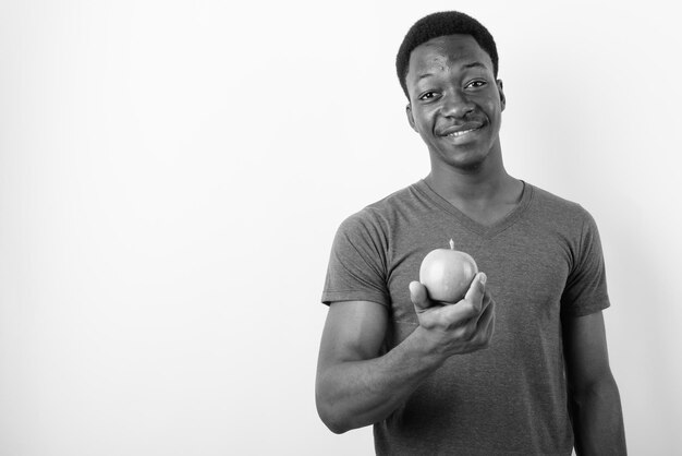 Photo portrait d'un jeune homme tenant une caméra sur un fond blanc