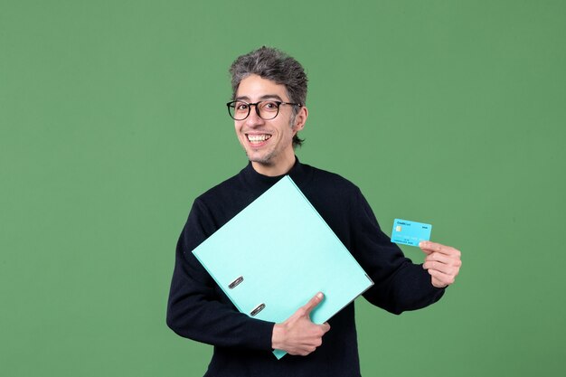 portrait de jeune homme tenant un document et une carte de crédit sur fond vert enseignants nature argent banque d'emplois masculins