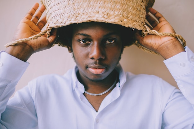 Portrait de jeune homme tenant un panier de paille au-dessus de sa tête