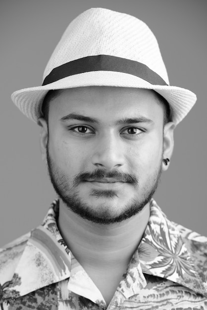 Portrait de jeune homme de tourisme indien barbu beau sur blanc en noir et blanc