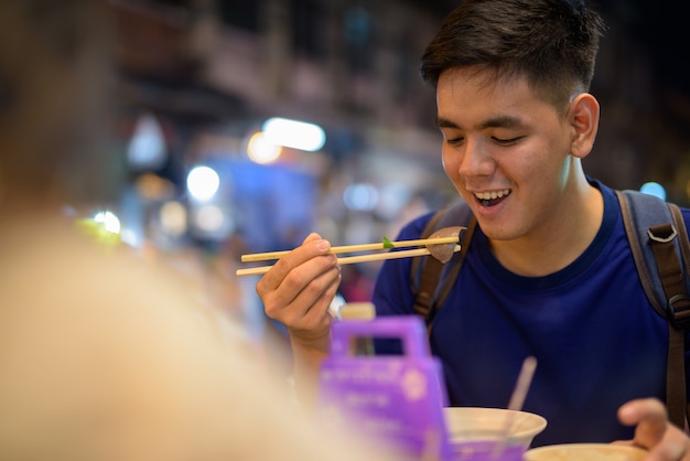 Portrait de jeune homme touriste asiatique beau explorer à Chinatown à Bangkok, Thaïlande