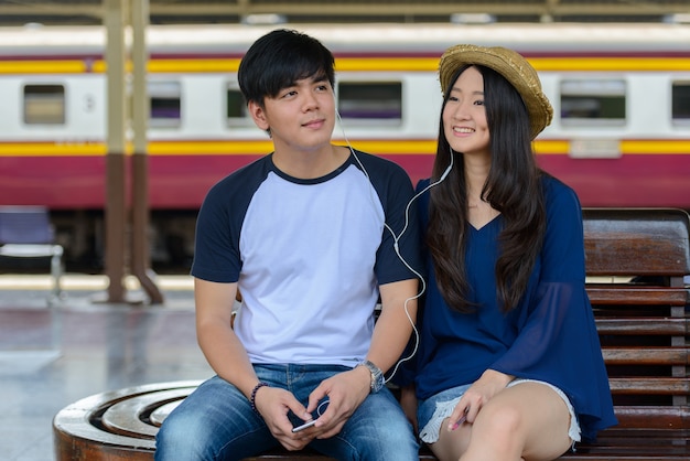 Portrait de jeune homme touristique philippin et jeune femme touristique asiatique ensemble et amoureux à la gare de Hua Lamphong