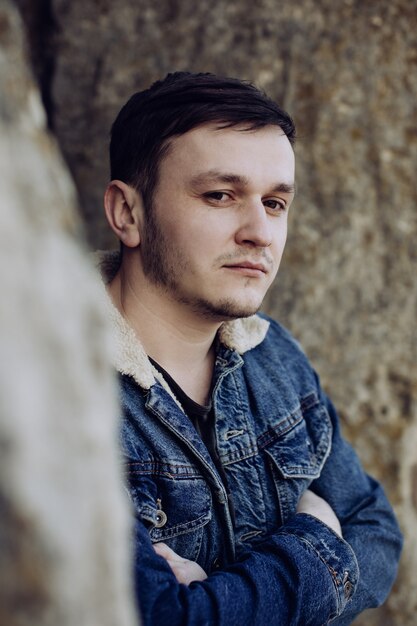 Portrait de jeune homme triste en veste en jean