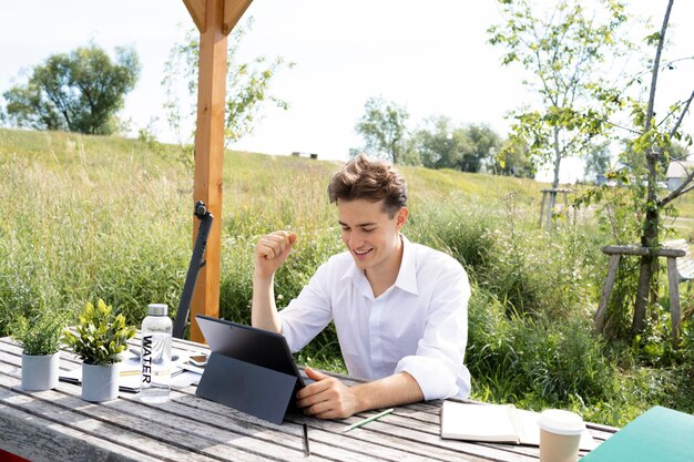 Photo portrait d'un jeune homme utilisant un ordinateur portable assis sur une table