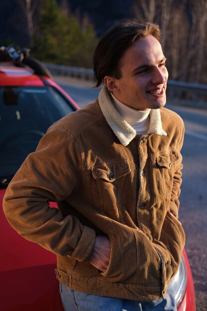 Portrait d'un jeune homme avec une voiture